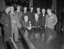 Original title:  Newfoundland and Canadian Government delegation signing the agreement admitting Newfoundland to Confederation. Prime Minister Louis S. St. Laurent and Hon. A.J. Walsh shake hands following signing of agreement. 