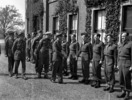 Titre original&nbsp;:  H.M.King George VI with Lt.Cols. D.J. Mingay, E.A. Cote and Gen. H.D.G. Crerar inspecting officers at 3rd Canadian Infantry Division Headquarters. (L-R): Maj. Lovering, Capt. Black, -, Capt. Sinkewicz,Lt. Asquith, Maj. Wickwire. 