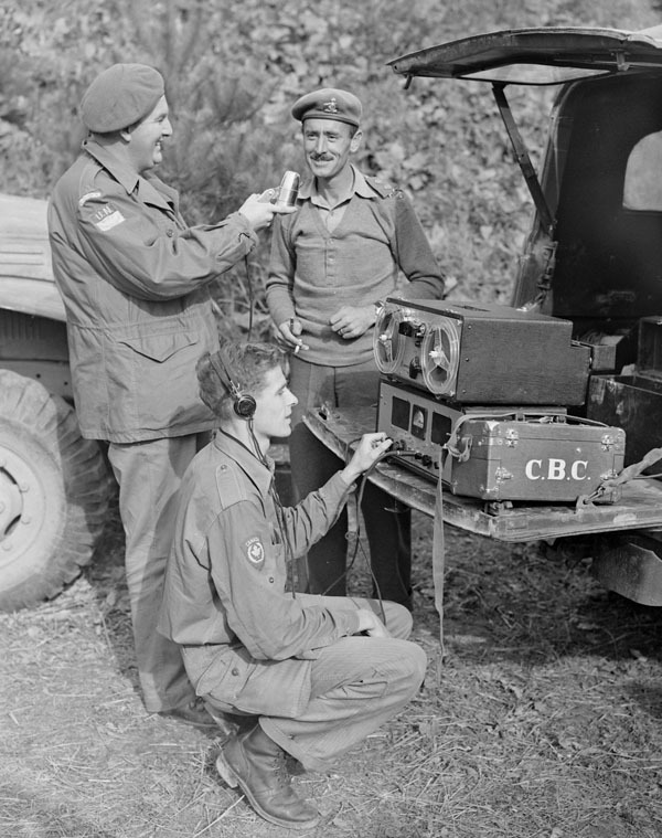 Original title:  Normand Eaves, at the mike, and Norman McBain, at the controls, interviewing Lt. Col. James Dextraze, commanding officer of the Royal 22nd Regiment. 